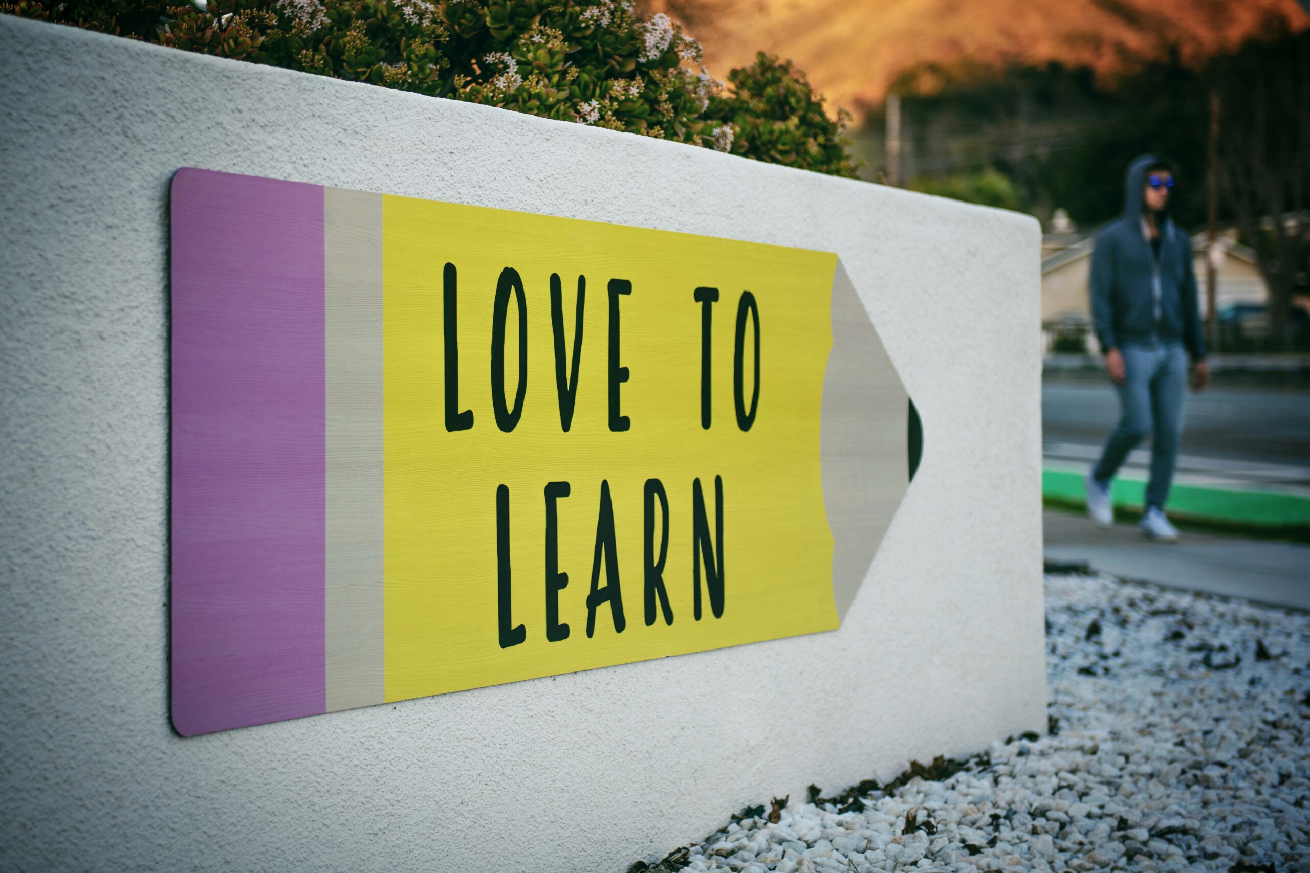 love to learn pencil love to learn pencil signage on wall near walking man