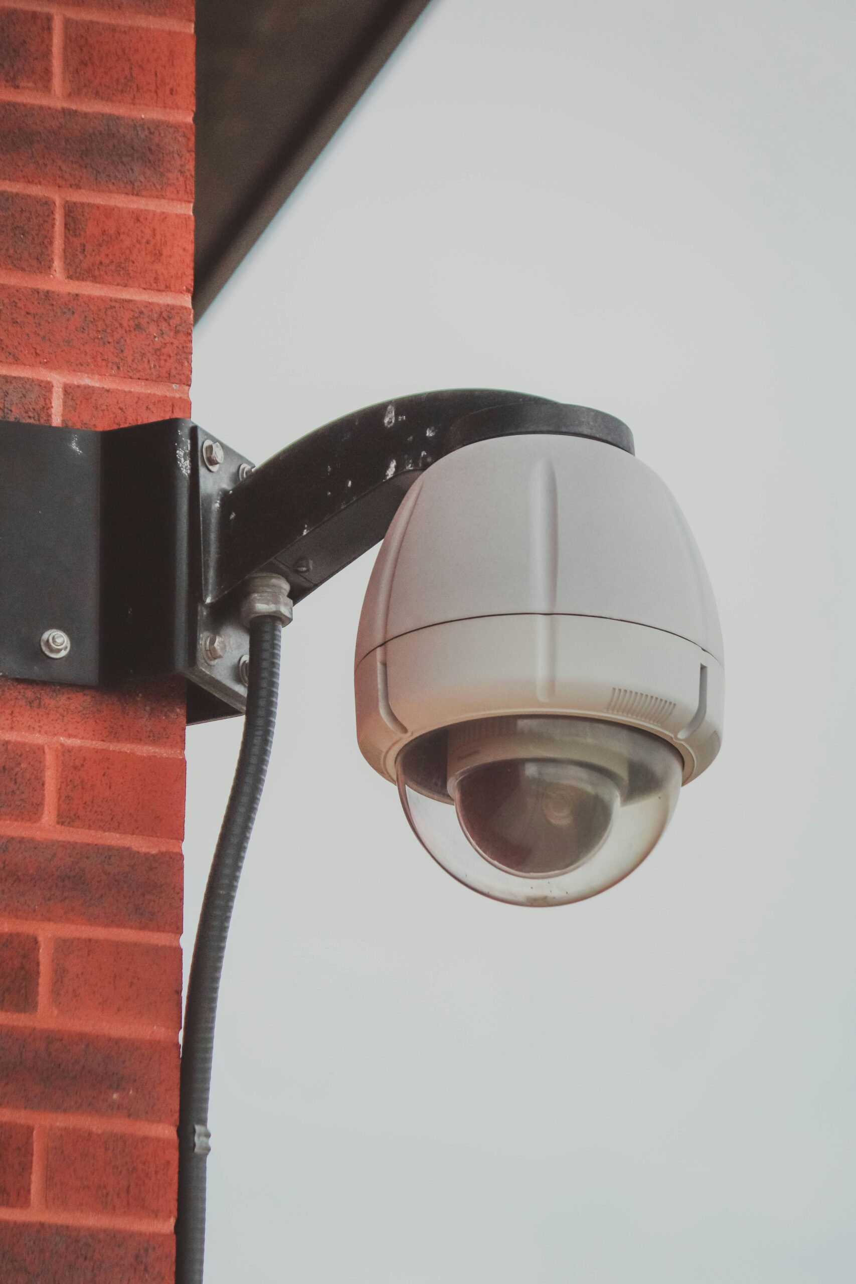 a security camera attached a security camera attached to a brick wall